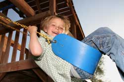 Young boy enjoying a ride on his swing set