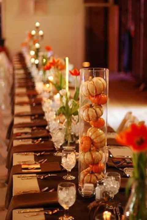 Thanksgiving tablescapes with hurricane lamps filled with pumpkins, plus flowers & candles