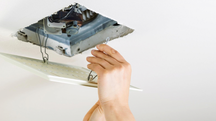 Installing a bathroom fan involves connecting wiring in the ceiling ...