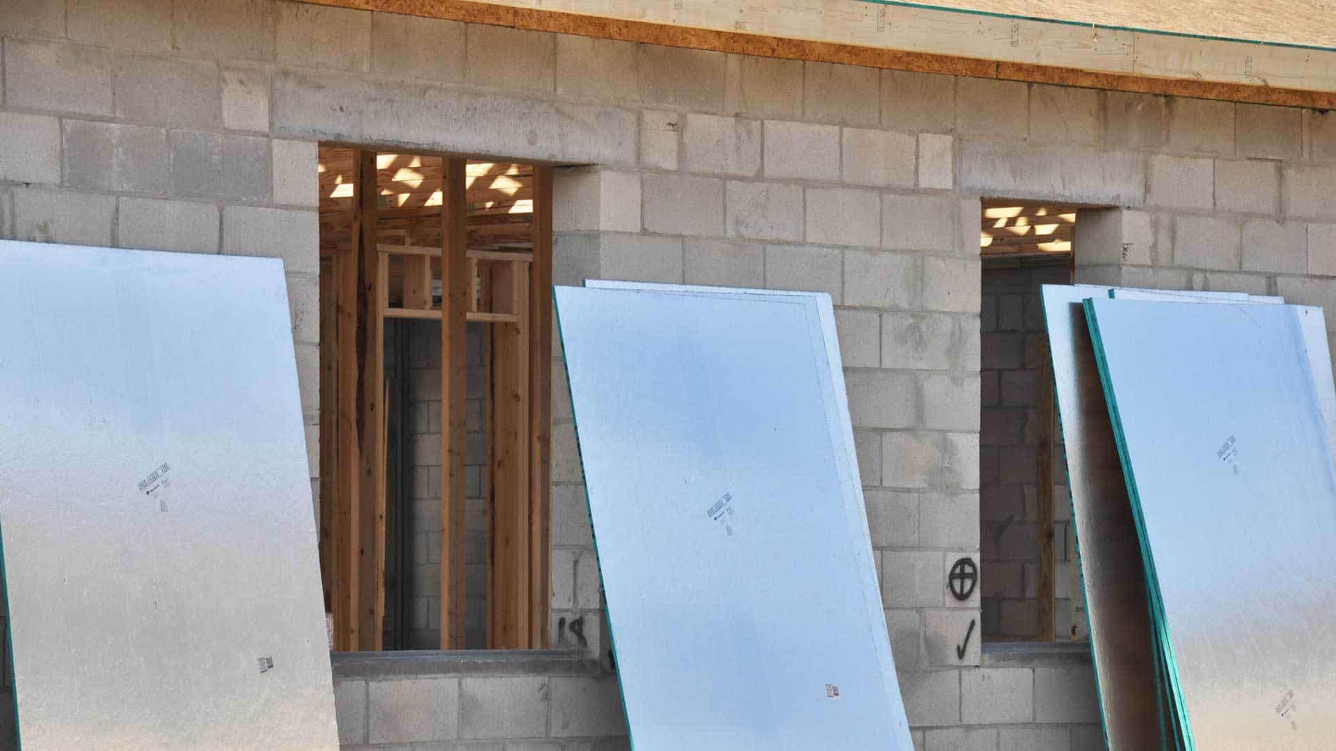 Close up view of several OSB radiant roof deck panels (4 by 8 ft) standing up around the house