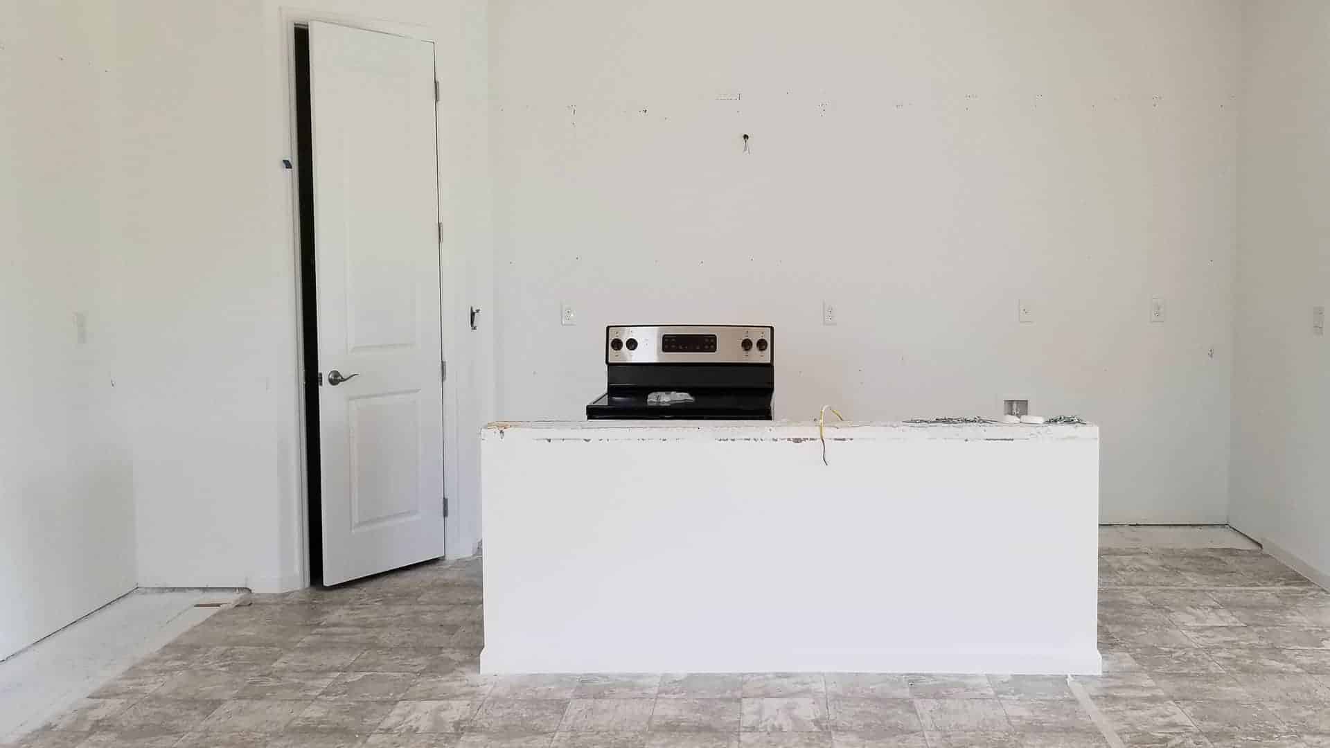 empty kitchen with island wall & stove after cabinets removed